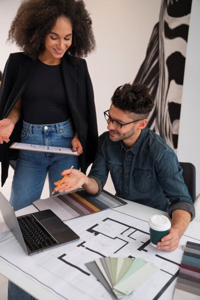 une femme et un homme observe un plan d'agencement intérieur